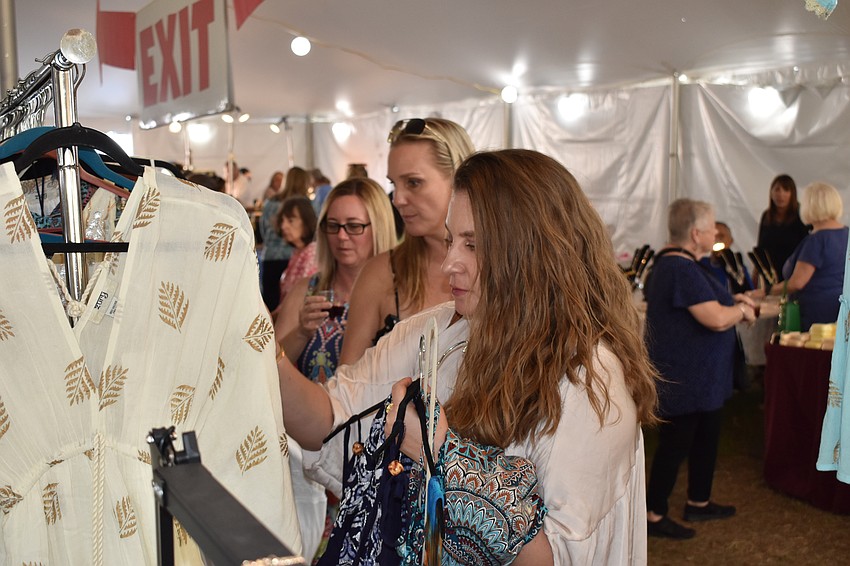 Sarasota's Shannon Bartram, Bradenton's Brenna Bartram, and Sarasota's Christina Dranzo decide which clothing items are best at the market.