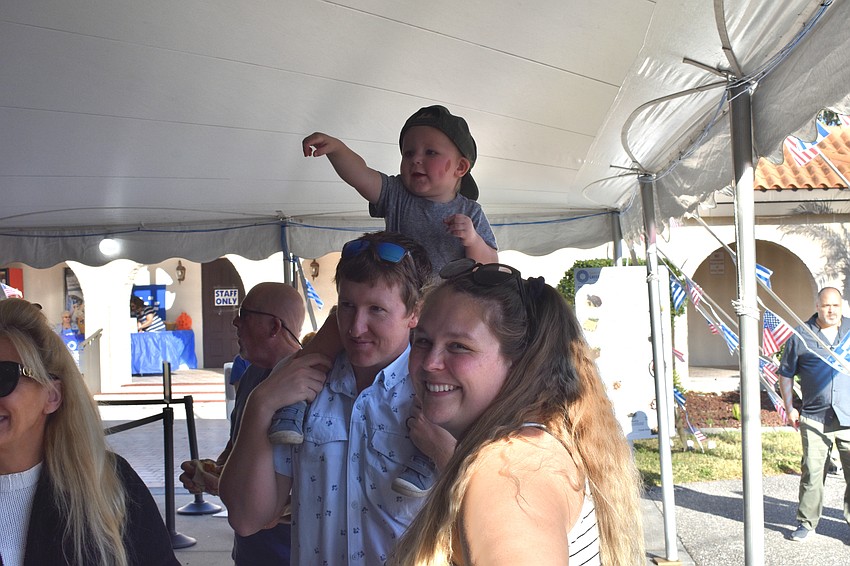 Sarasota's Cliff Lindsay, one-year-old CJ Lindsey, and Brittany Lindsey, watch the dancing.