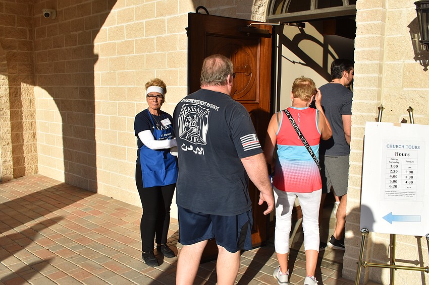 Sarasota's Althaia Vitikos invites guests into the church.