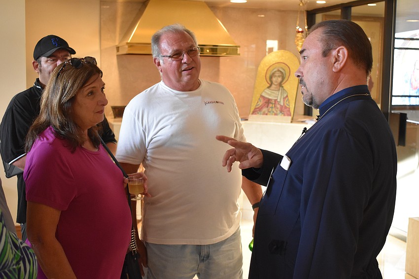 Sarasota's Sandy and John Tromboni speak with Father John Bociu.
