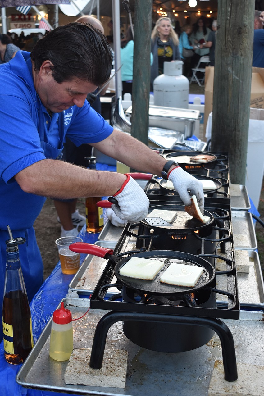 Bradenton's Zack Kallis prepares slices of flambeed cheese.