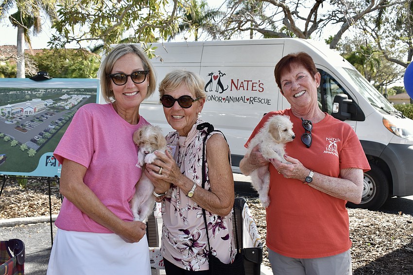 Jill Hennessey, Marilyn Huseby and Carol Patulo play with the puppies.