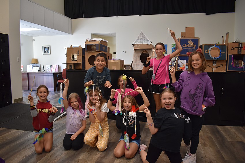 Kids showoff their handmade cat toys while pretending to be cats.