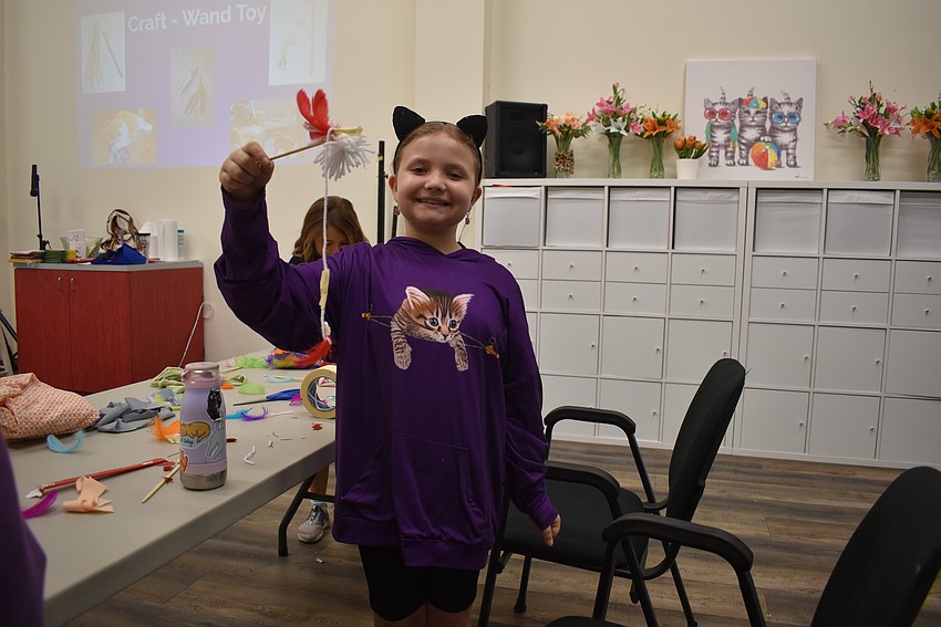 Abby Graison showsoff her cat toy in her cat ears and cat sweater.