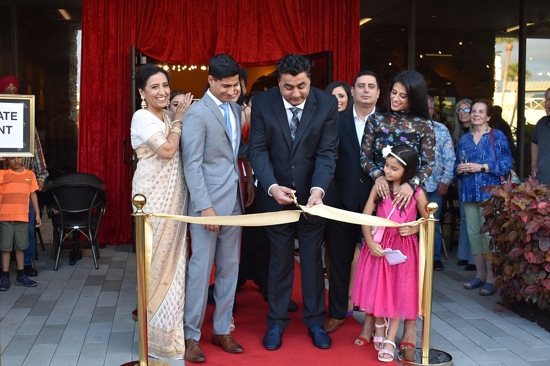 Chef Swaran Singh (center) cuts the ribbon during the grand opening of Tandoor Fine Indian Cuisine. Owners Poonam Maini and Shubi Maini are on the left.