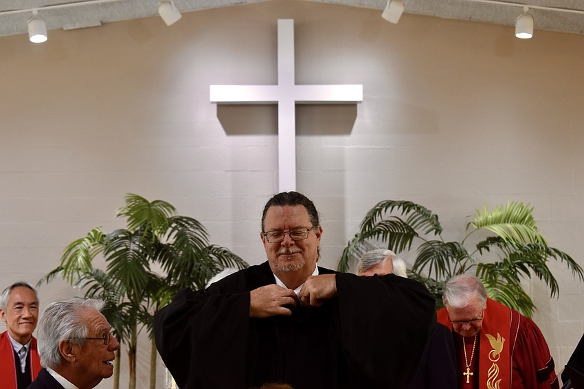 Jeffrey Nunes zips up his robe as a reverend for the first time.