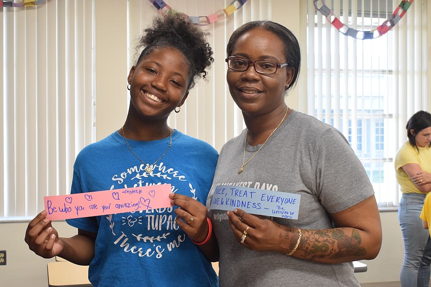Fifth grader Cayden Hunter and her mother, Tara Davis, write notes of kindness to add to a chain of kindness. 