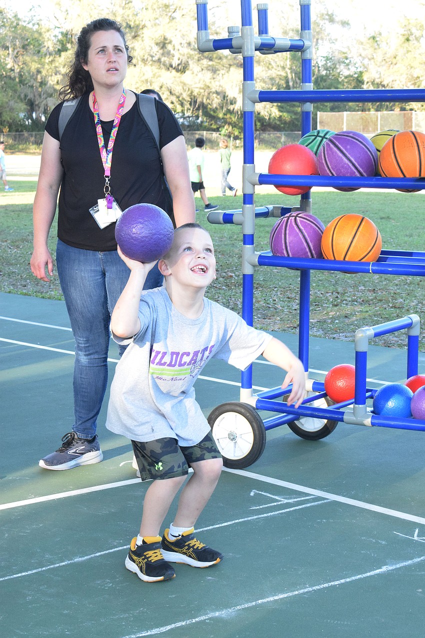 Stephanie Tretolo, a fourth grade teacher at William H. Bashaw Elementary School, watches her son Anthony Tretolo, who is in pre-K at Gilbert W. McNeal Elementary School, play basketball.