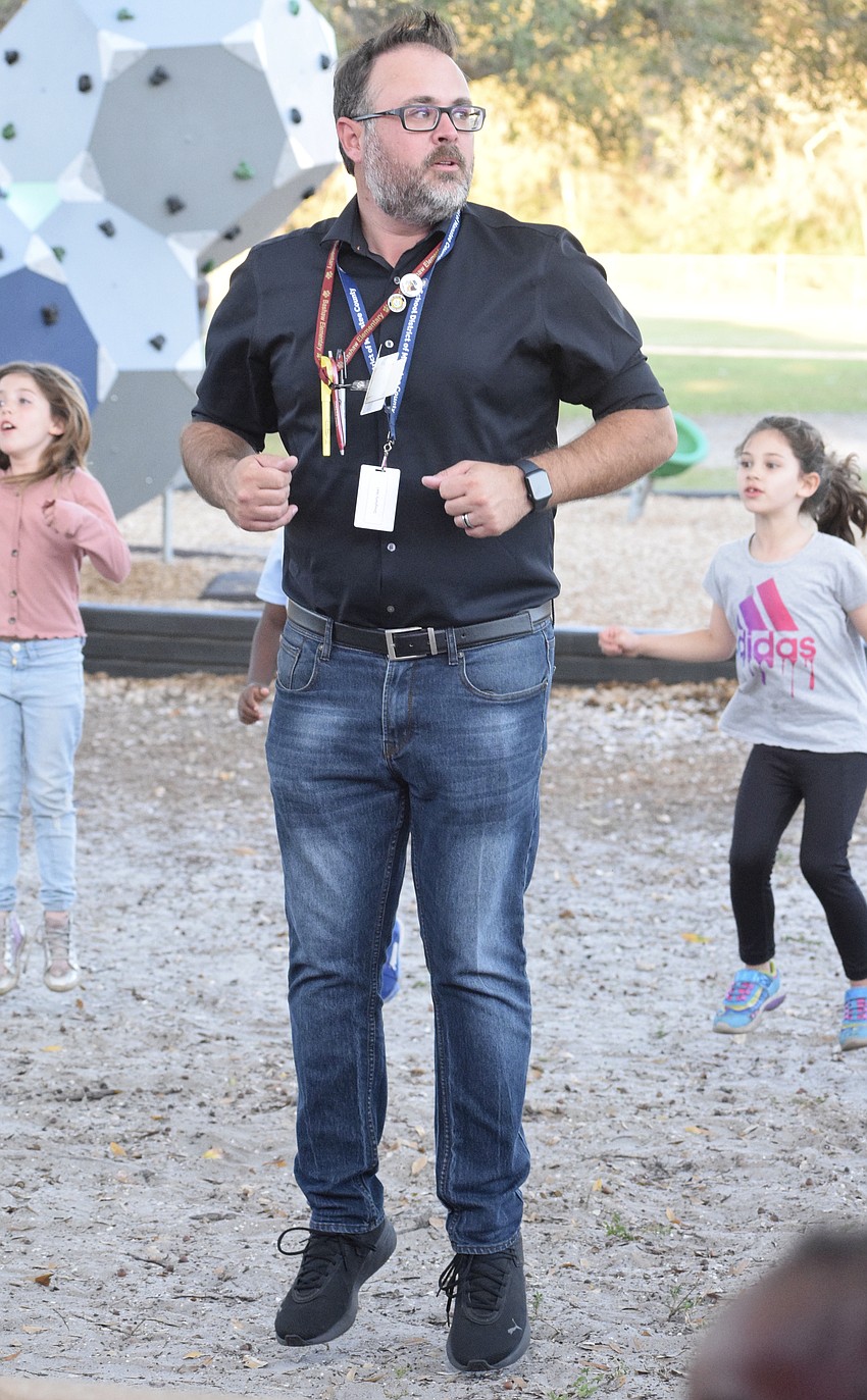 James Dougherty, the principal at William H. Bashaw Elementary School, dances with students to the 