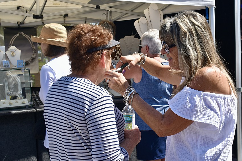 Arlene Skversky gets help from Ronetta Krause of Silver Moon Studio with a pair of earrings.