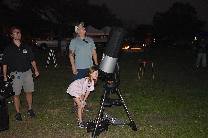 Alex Martin of Sidewalk Science Center tells Lorraine Lakes' Danny Norris and 9-year-old Cainlynn Norris about the stars.