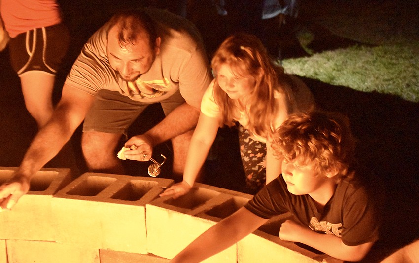 Harmony's Joseph Revis, 6-year-old Lia Revis, and 11-year-old Nicholas Revis enjoy the campfire and roast marshmallows at the Community Campout.