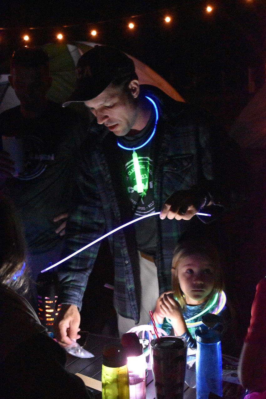 Dan Barshinger and 5-year-old Cora Barshinger give out glow sticks at the Community Campout.