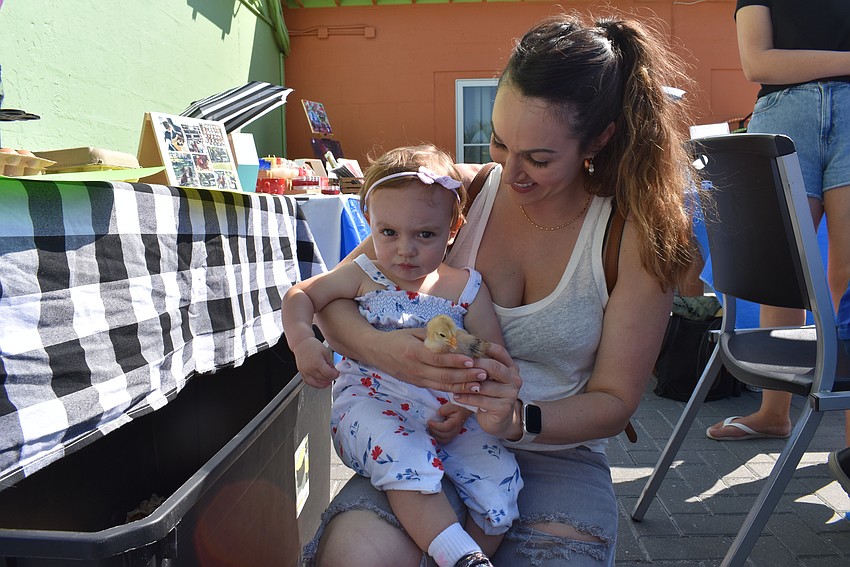 Aurora and Stephanie Cramer hold a chick for a dollar in support of Max and Sam's small business.