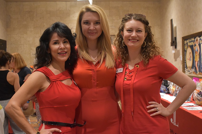 Cici Couchot, Kanna Shepherd and Maddie Tympanick help attendees with the silent auction.