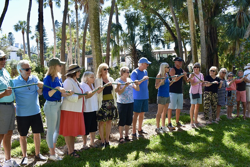 Instead of cutting a ribbon, community members hold the hose and drop it.
