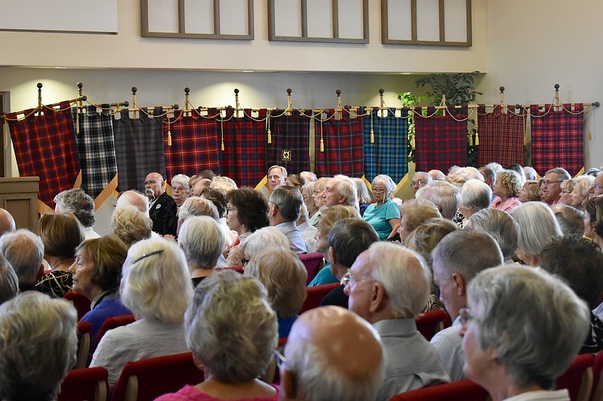 Tartan banners line the front wall of the church after being carried in by members of the congregation.