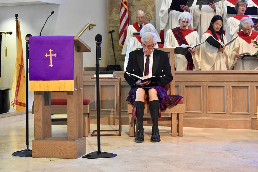 Pastor Norman Pitchard presides over service wearing traditional Scottish garb.