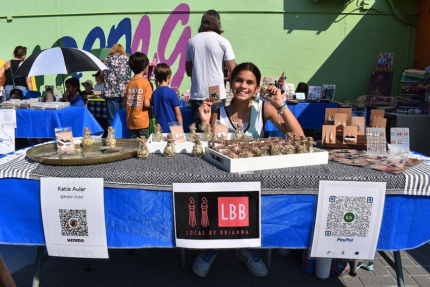 Brianna Aular sets up her booth 'Local by Brianna' ready to make business transactions.