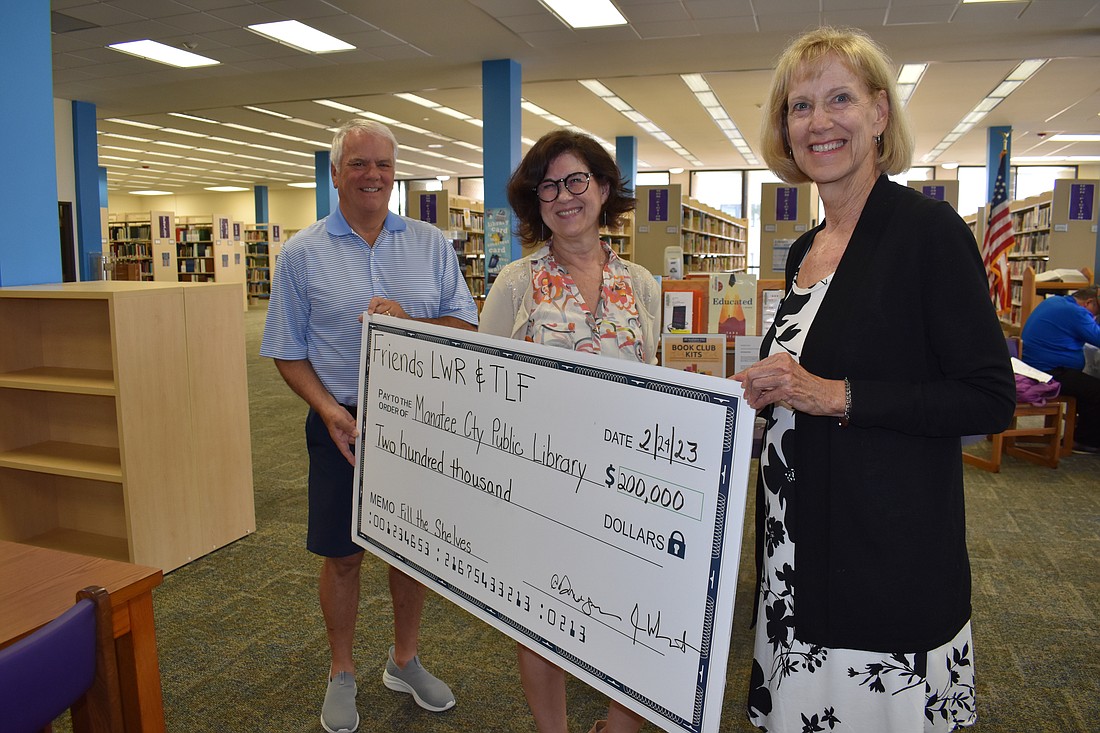 Don Janezic, president of the Manatee Library Foundation; Tammy Parrott, the Manatee County library services services manager; and Sue Ann Miller, president of the Friends of the Lakewood Ranch Library, hold a $200,000 check that was presented to library services.