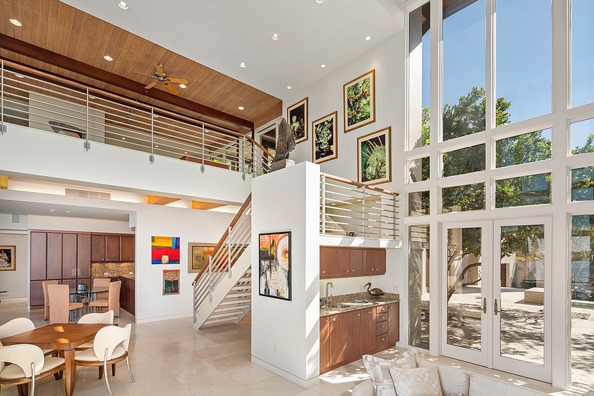 The living room is two stories with floor-to-ceiling windows.