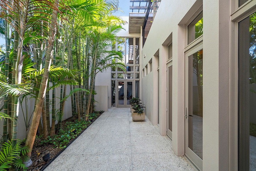 The property is surrounded by tropical landscaping and a privacy wall.