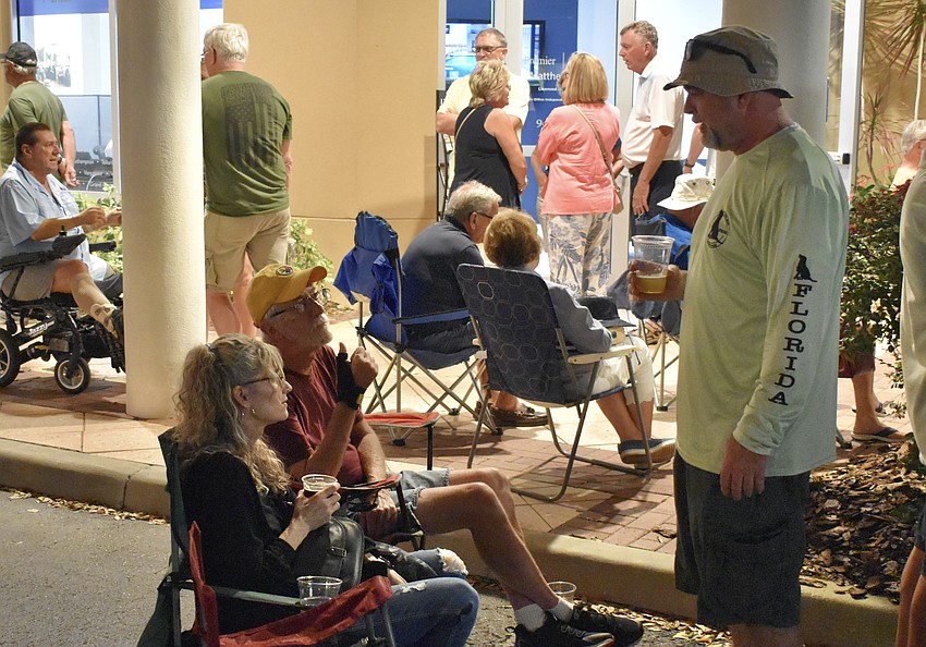 Lakewood Ranch's Beth Wood, her father John James from Ohio, and her husband Brian Wood, pick out a good spot on the street before the band begins.