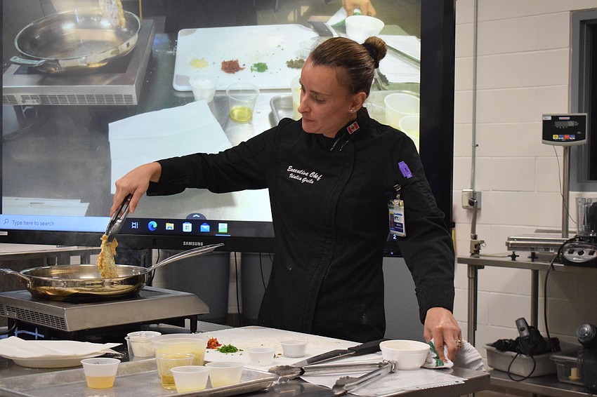 Manatee Technical College Executive Chef Idalia Grilo flips her chicken. “The objective here is not to do the flippy flippy,” Grilo says, cautioning everyone to be patient as the chicken was cooking in the pan.