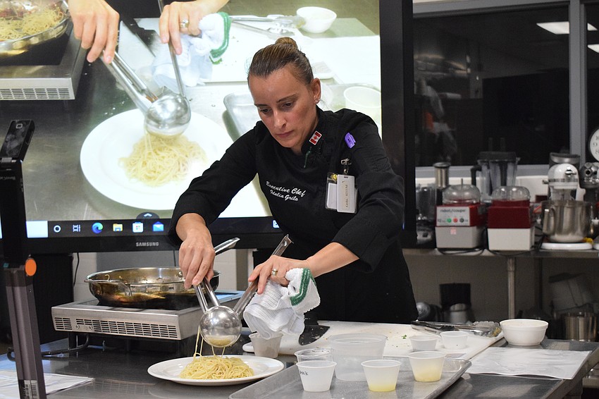 Manatee Technical College Executive Chef Idalia Grilo puts the pasta on a plate before adding her chicken piccata.