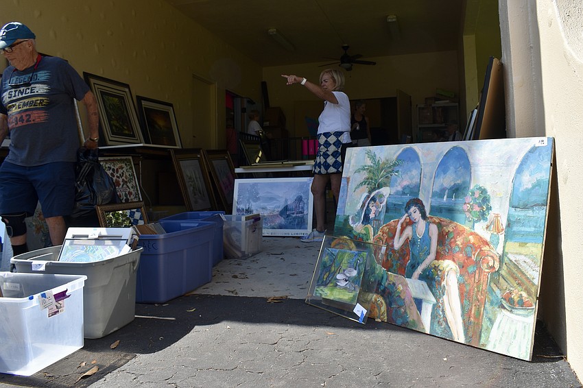 Artwork and furniture are on sale outside.