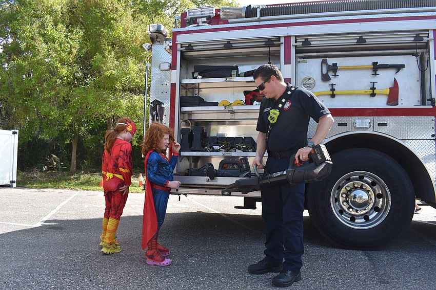 Avi Sigal and Joah Sigal meet Firefighter Allen Simunovic at Temple Emanu-El Purim Carnival.