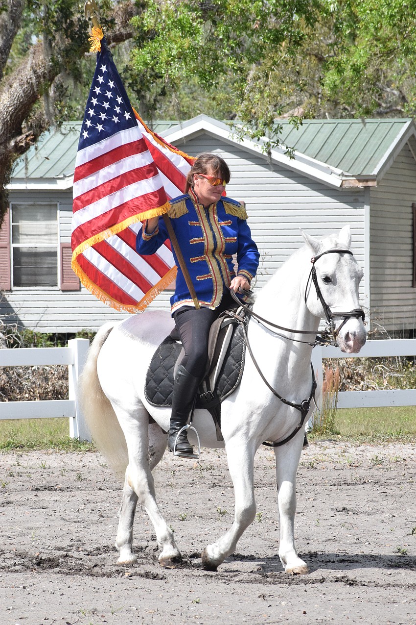 Julie Herrmann presents the American flag during the National Anthem.