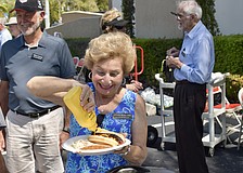 Joyce Roslund puts mustard on her hotdog.
