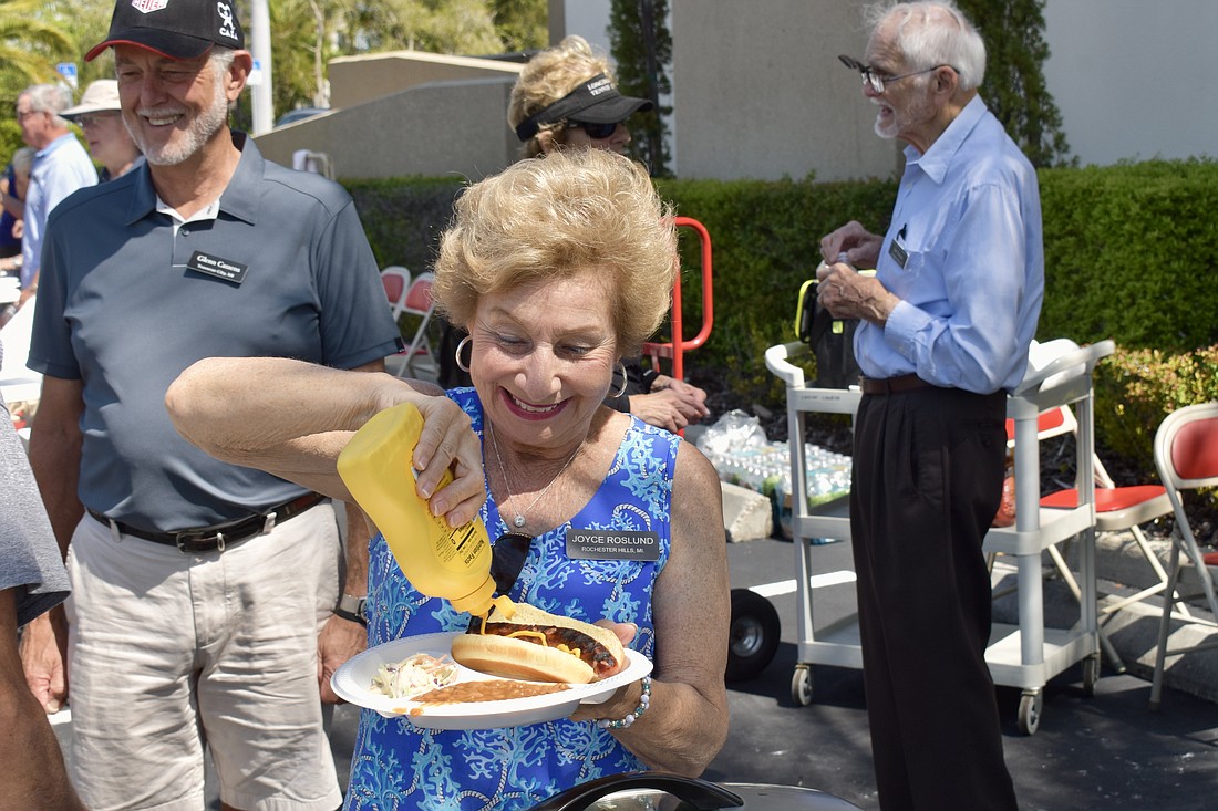 Joyce Roslund puts mustard on her hotdog.