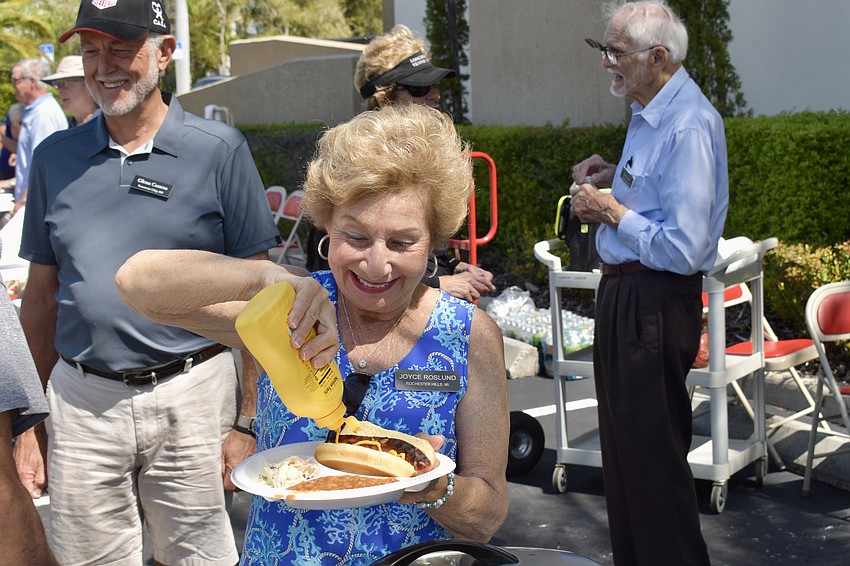 Joyce Roslund puts mustard on her hotdog.