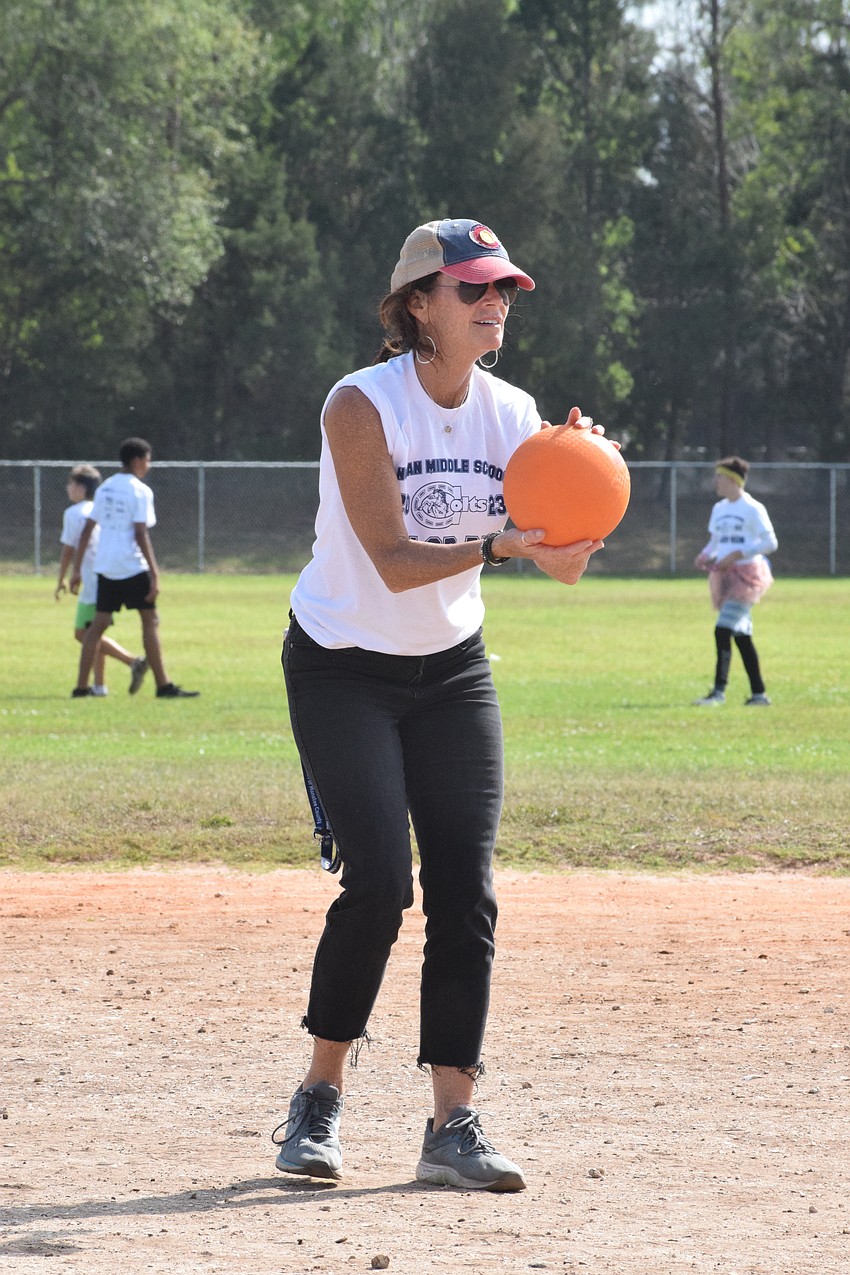 Stefani Heidenthal, a teacher, prepares to pitch the ball in a kickball game against students.