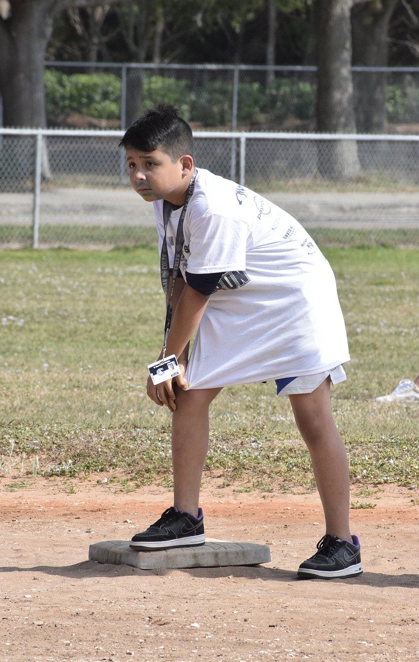 Sixth grader Francisco Sanchez prepares to make a run for third base during a kickball game against R. Dan Nolan Middle School staff.