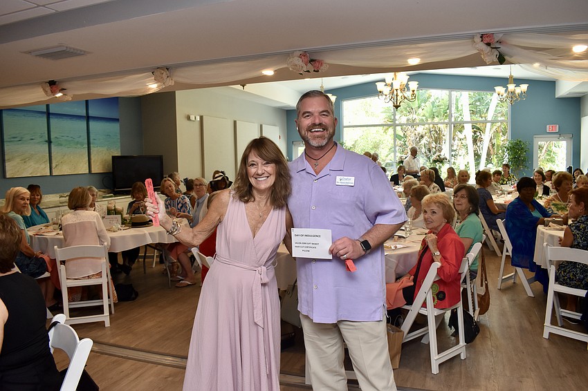 Anne Hasenfus takes Rev. Brock Patterson's winning raffle ticket.