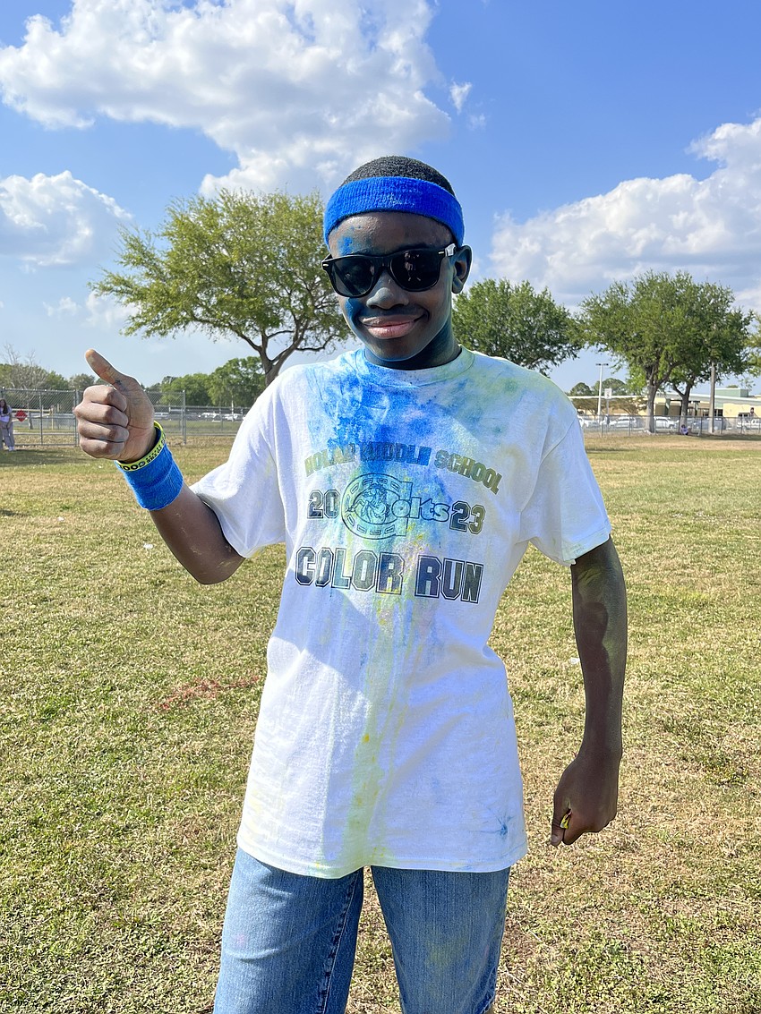Jabari Nelson, an eighth grader, gives the Color Run a thumbs up. He says he likes running through all the colors.