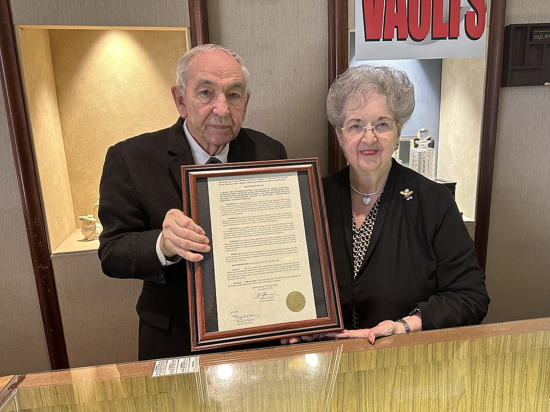 Jacobs Jewelers owners Ray and Delorise Thomas show off their framed Jacksonville City Council resolution.