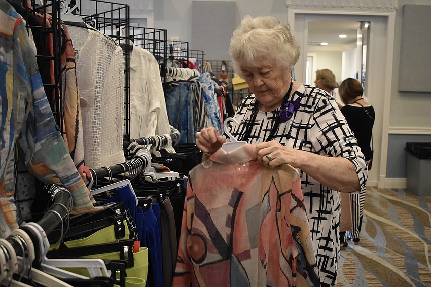 Cascades' Bonnie Reeves browses through outfits during the fashion show.