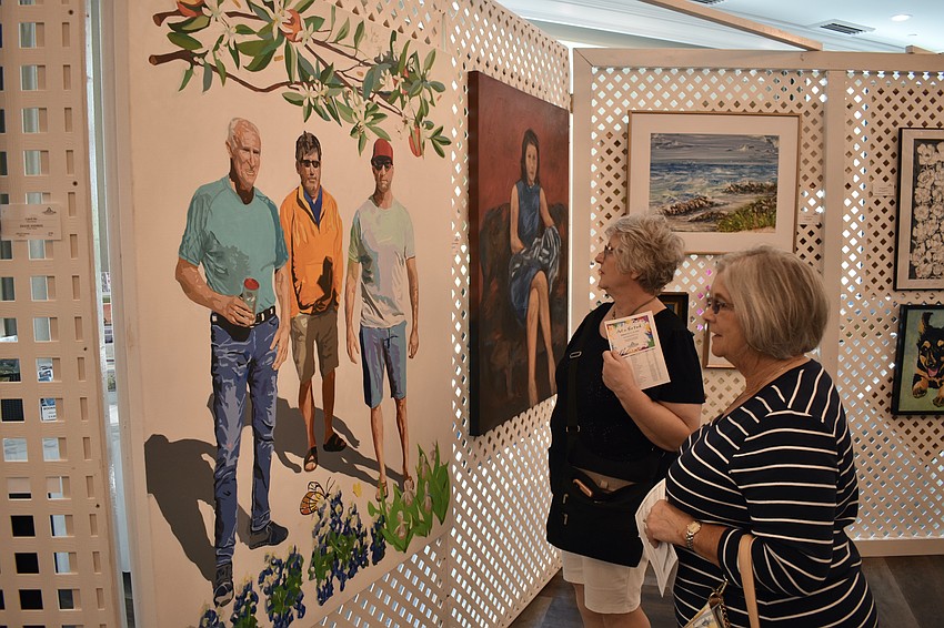 Friends and former neighbors Susan Lewis from New York, and University Park's Jean Sieghardt, enjoy their reunion at the art show.