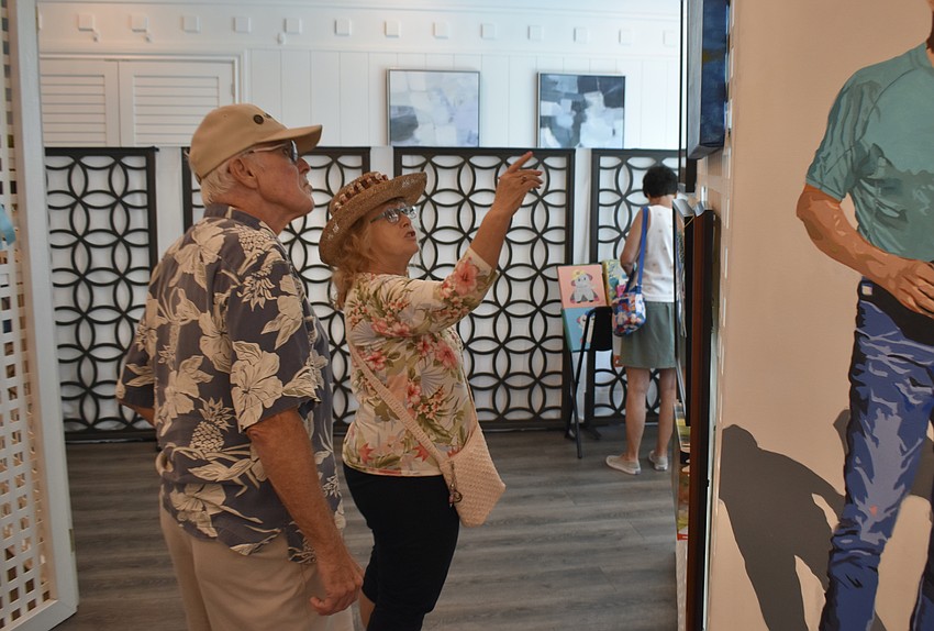 Sarasota's Dave and Debra Best discuss the works at the exhibit.