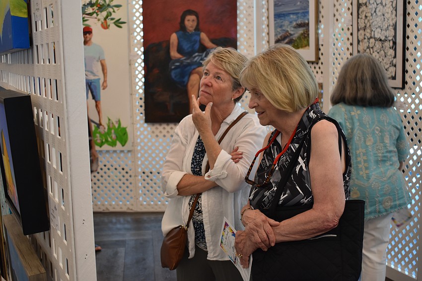 University Park's Carolyn Magnan and Lynn Reed check out the work of their neighbors.