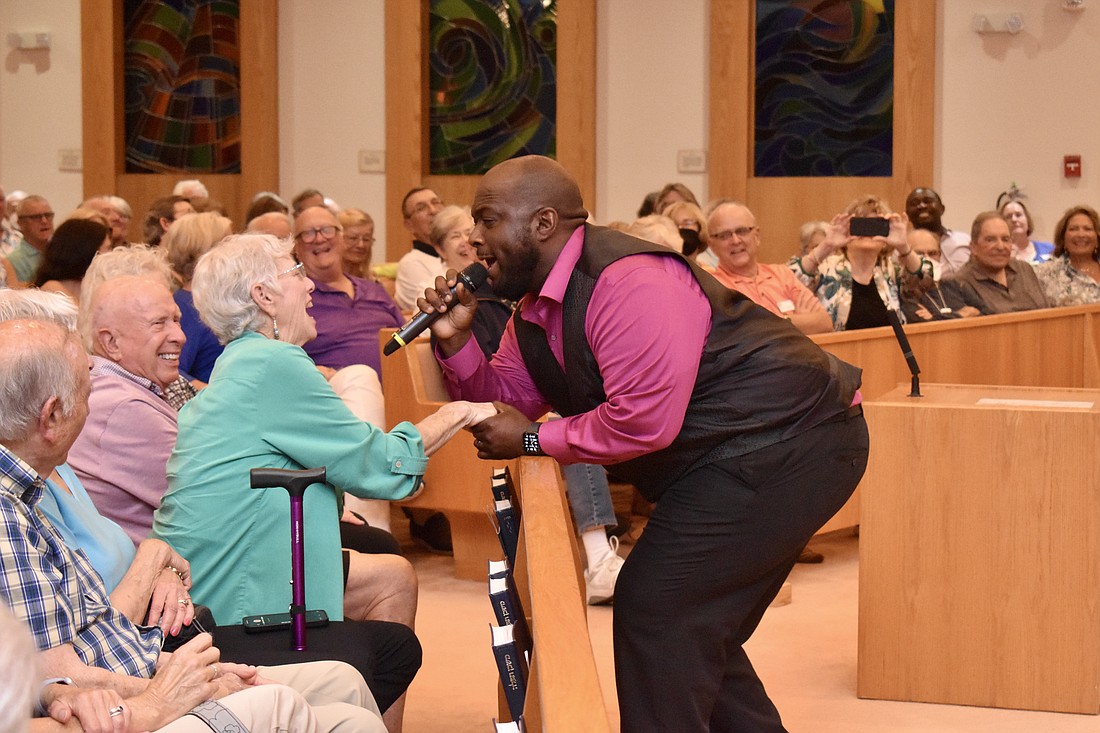 Leon Pitts II sings to an audience member.