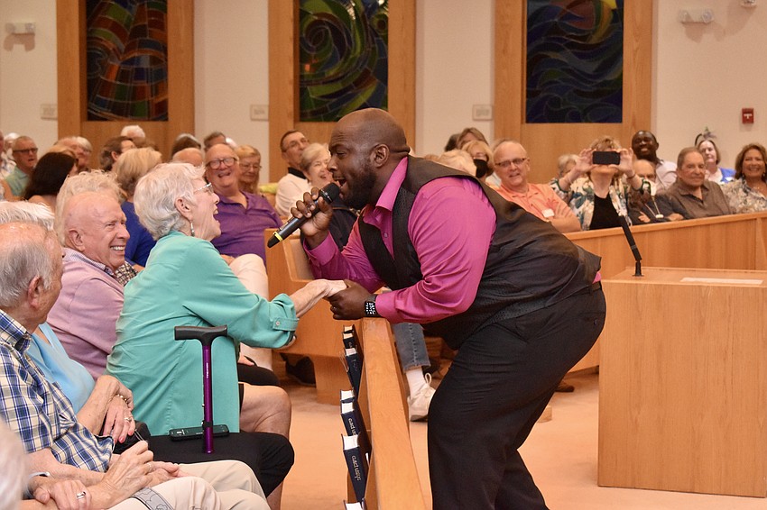 Leon Pitts II sings to an audience member.