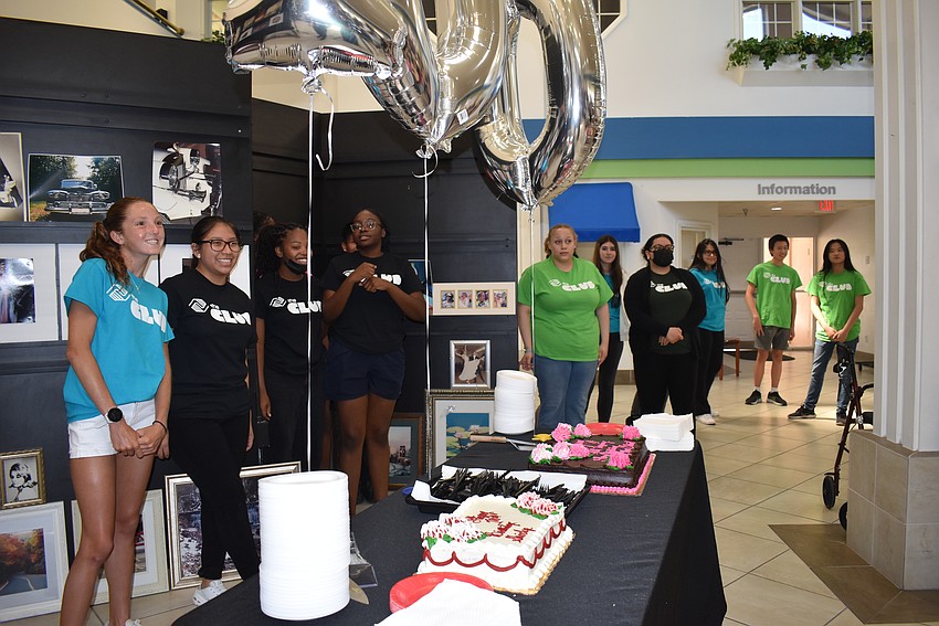 The Boys & Girls Clubs members volunteer to hand out slices of cake to the guests.