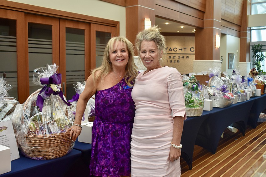 Kathy Callahan and Kim Rummel stand in front of the raffle prizes.