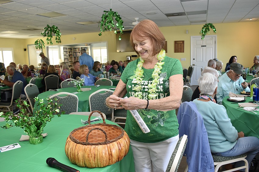 Sherrie Mondus adds her tickets to the 50/50 raffle basket.