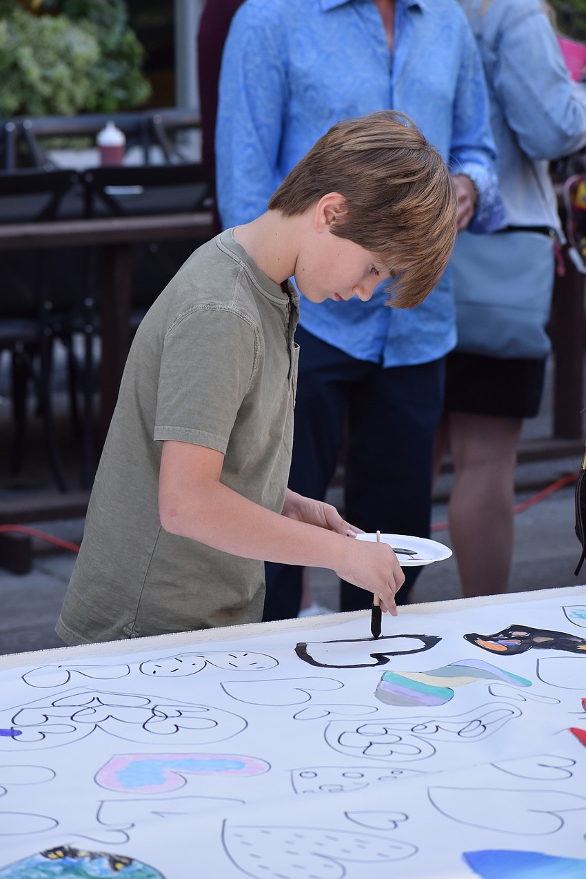 10-year-old Kai Petersen makes an addition to the community art piece.